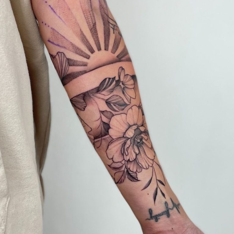 Beispielbild Tattoo Tattoo eines Sonnenaufgangs und Blumen auf dem Unterarm.